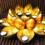 Gold lotus-style tea light candle holder with eight surrounding cups or petals for candles