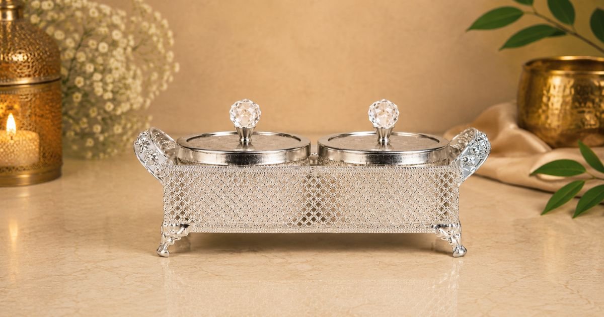 Silver ornamental double-lidded caddy with crystal knobs on a beige countertop
