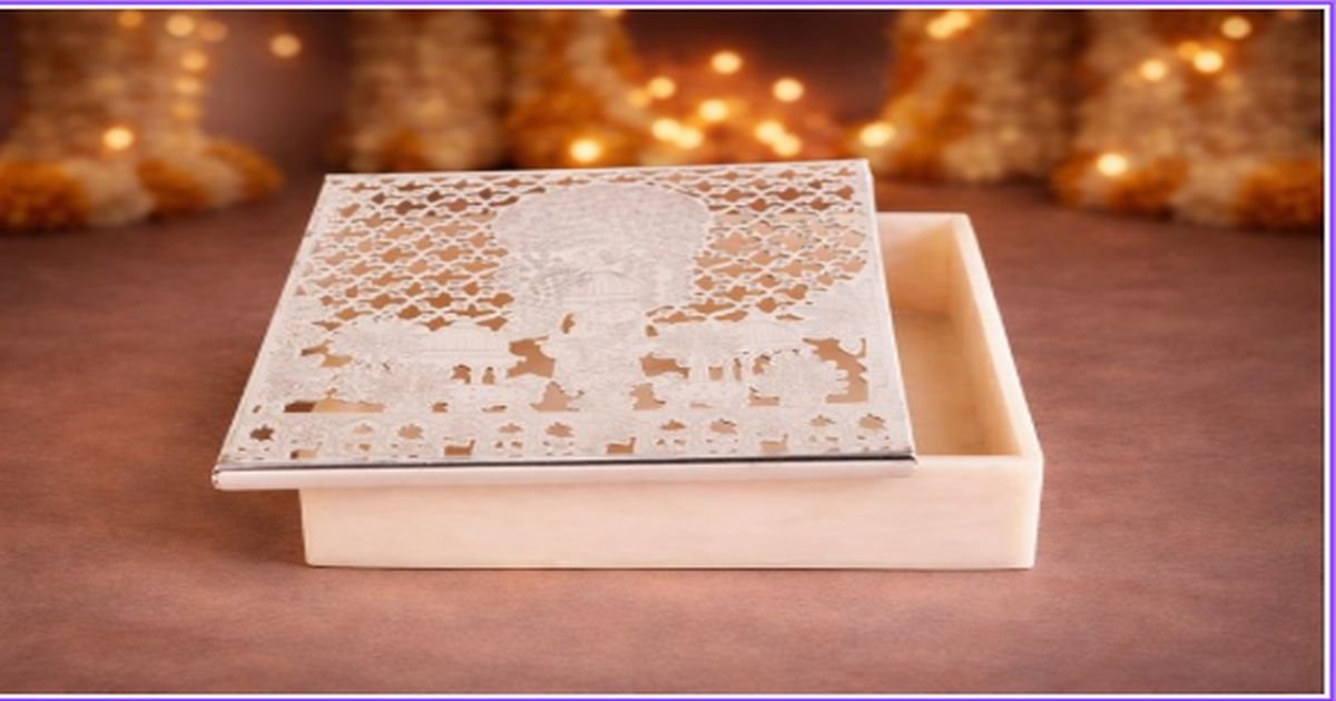 IVORY jewelry box with an intricate lace-pattern lid, partially open on a brown surface with warm holiday lights in the blurred background.