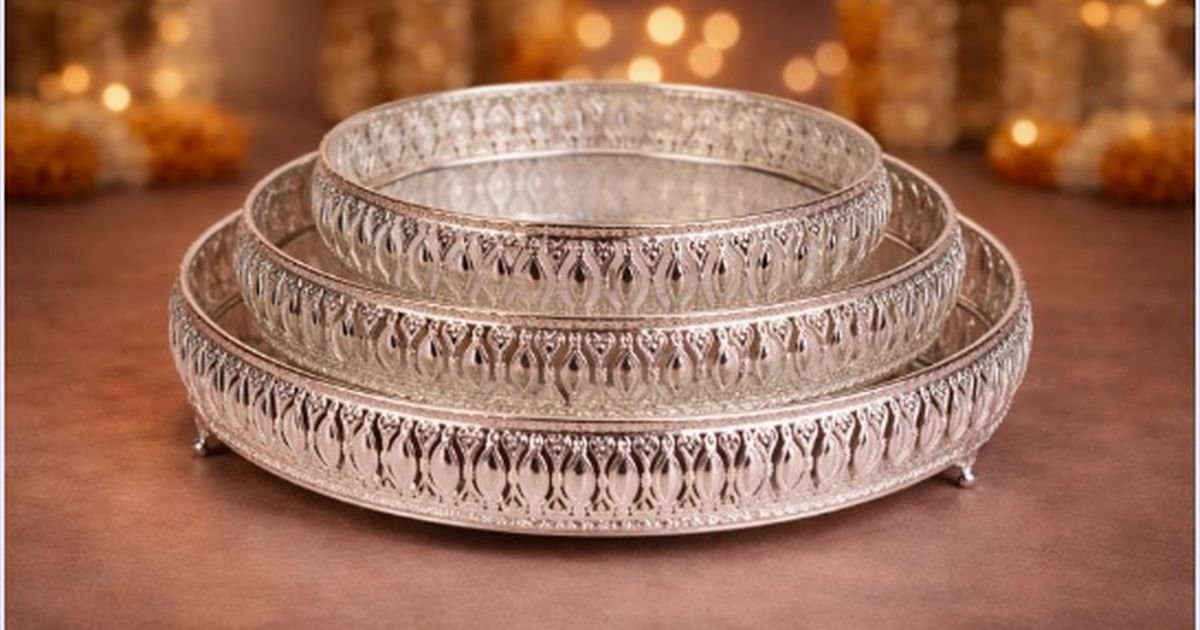 Stack of ornate silver filigree bangles displayed on a wooden surface.