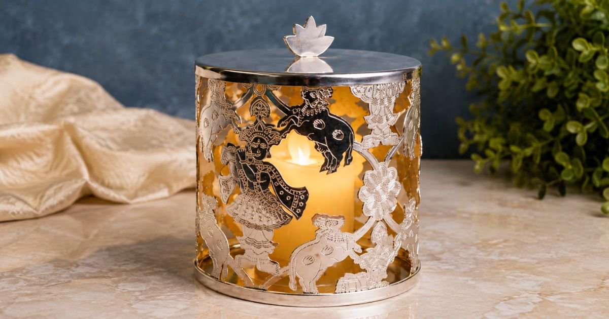 Decorative metal lantern with intricate lace-like cutouts and a lit candle inside.