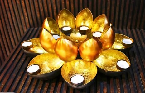 Gold lotus-style tea light candle holder with eight surrounding cups or petals for candles